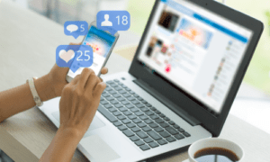Image of laptop and mobile phone with graphics indicating social media likes.