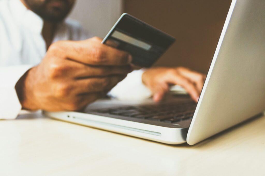 q59hmzk38eq - How to Set Up Recurring Payments for Martial Arts Memberships person using laptop computer holding card
