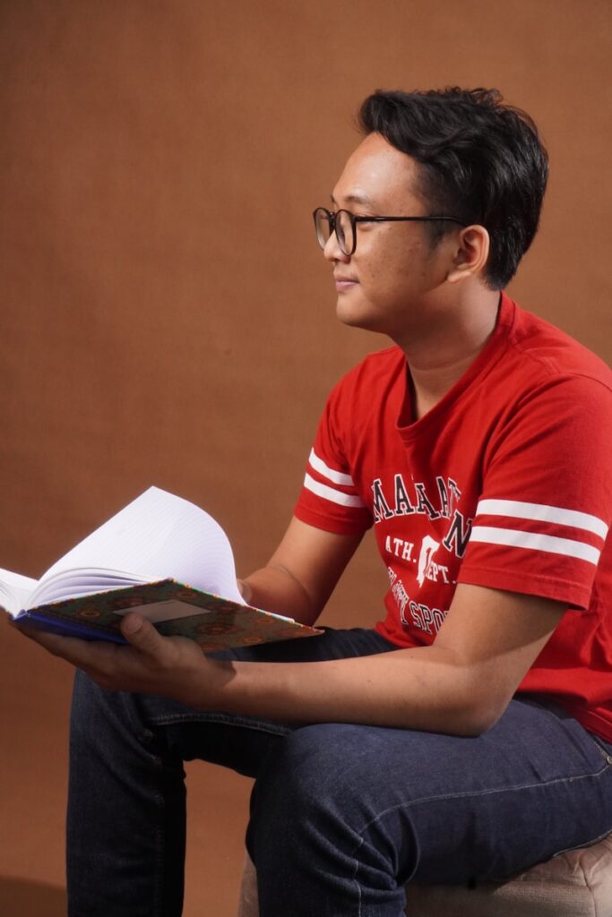 xpssaprsysq - The Power of Reviews: How to Get and Use Student Testimonials Effectively a man sitting on a stool reading a book